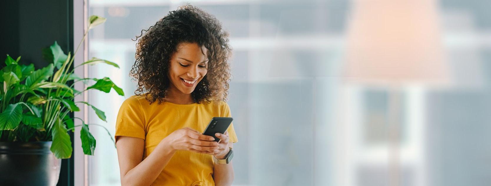 A woman manages her banking accounts using the Patelco mobile app on her phone.